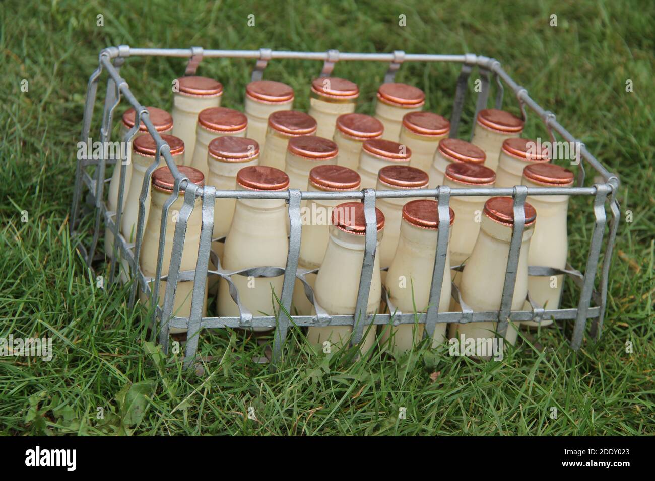 Ein Becher mit kleinen Glas-Milchflaschen aus Vintage-Glas. Stockfoto