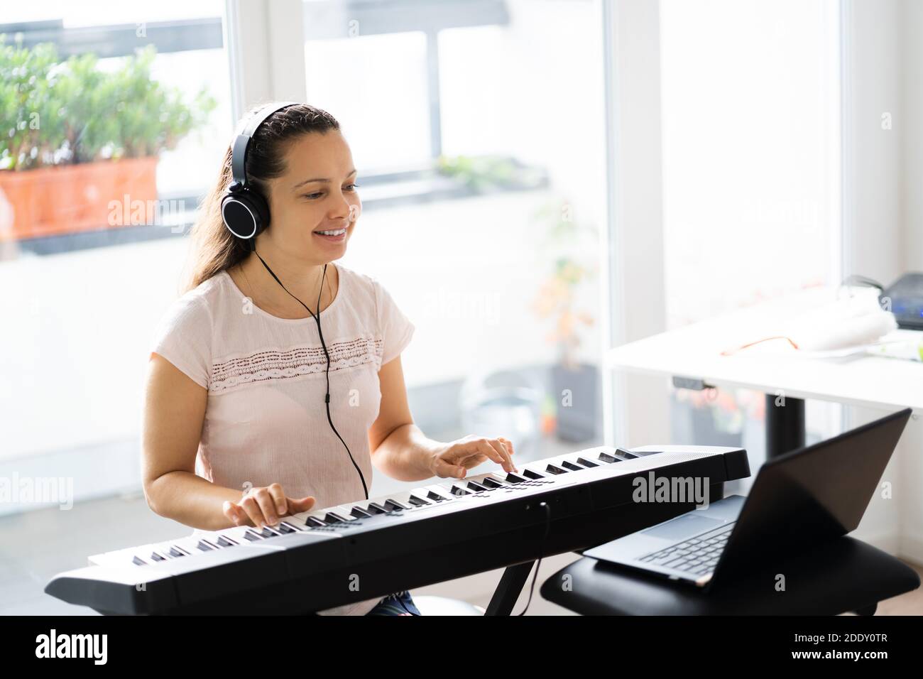 Frau Spielt Musik Keyboard Piano Instrument Zu Hause Stockfoto