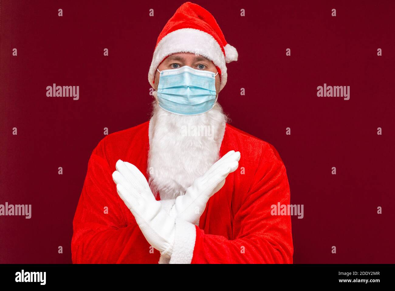 Nahaufnahme weihnachtsmann Kostüm Ablehnung Ausdruck Kreuzung Arme und Handflächen tun negative Zeichen, trägt medizinische Maske.Vorderansicht Bild. Stockfoto