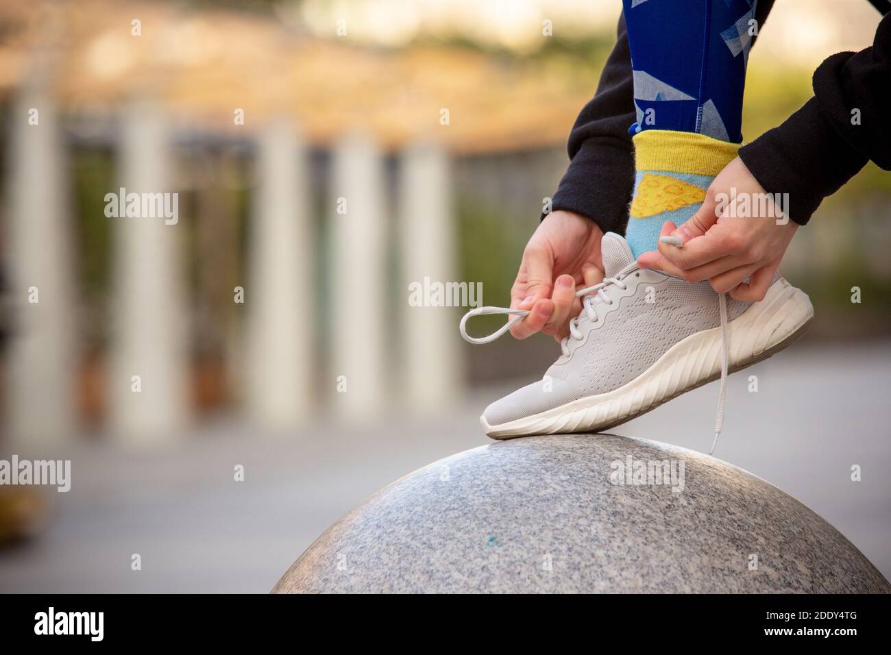 Weibliche Fitness-Läuferin, die Sportschuhschnüren bindet. Nahaufnahme von Händen und Beinen. Stockfoto
