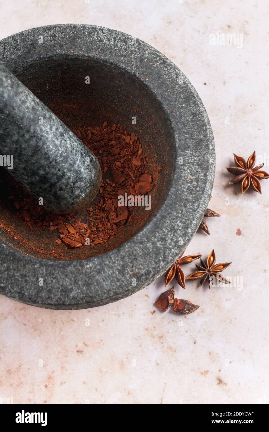 Sternanis wird von Hand mit Stößel und Mörtel gemahlen. Stockfoto