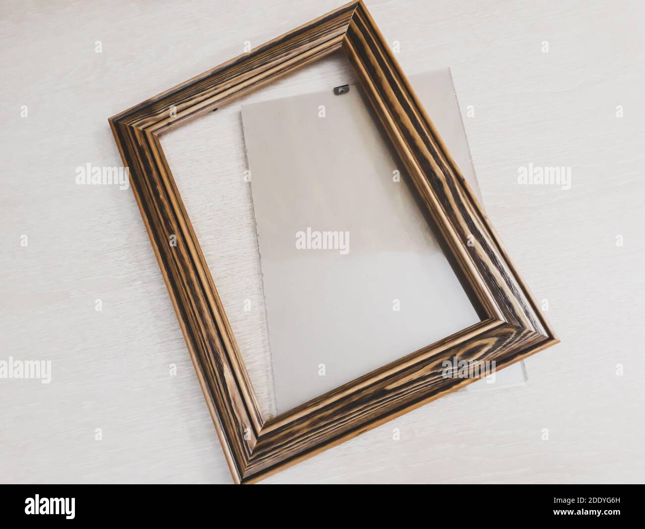 Rahmen aus dunklem Holz für Nadelarbeit auf hellem Hintergrund, horizontales Foto Stockfoto