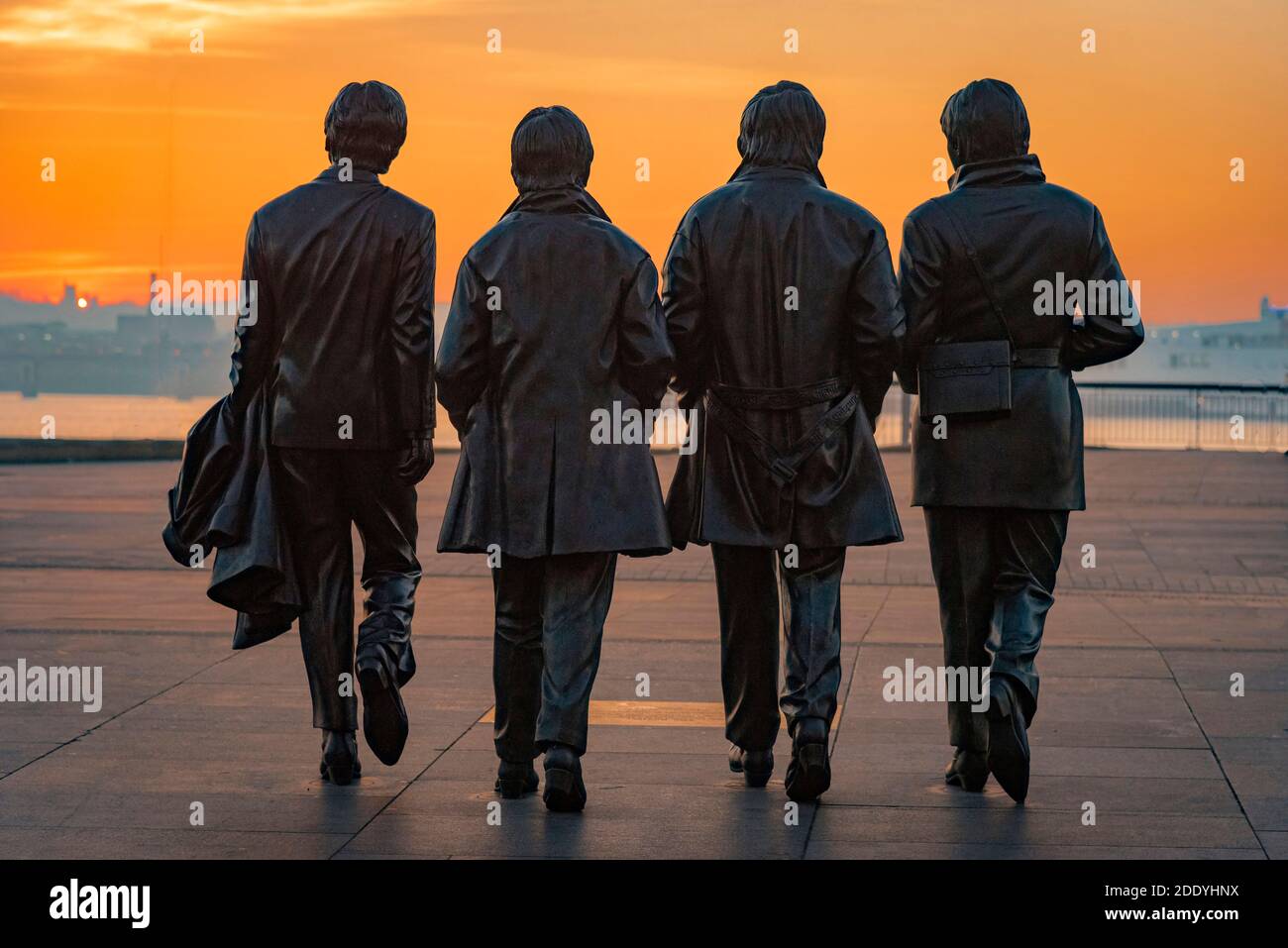 Statue der Beatles oder Fab Four am Liverpool Pierhead in der Abendsonne. Eine Lampost hs wurde aus diesem Bild Airbrushed. Stockfoto
