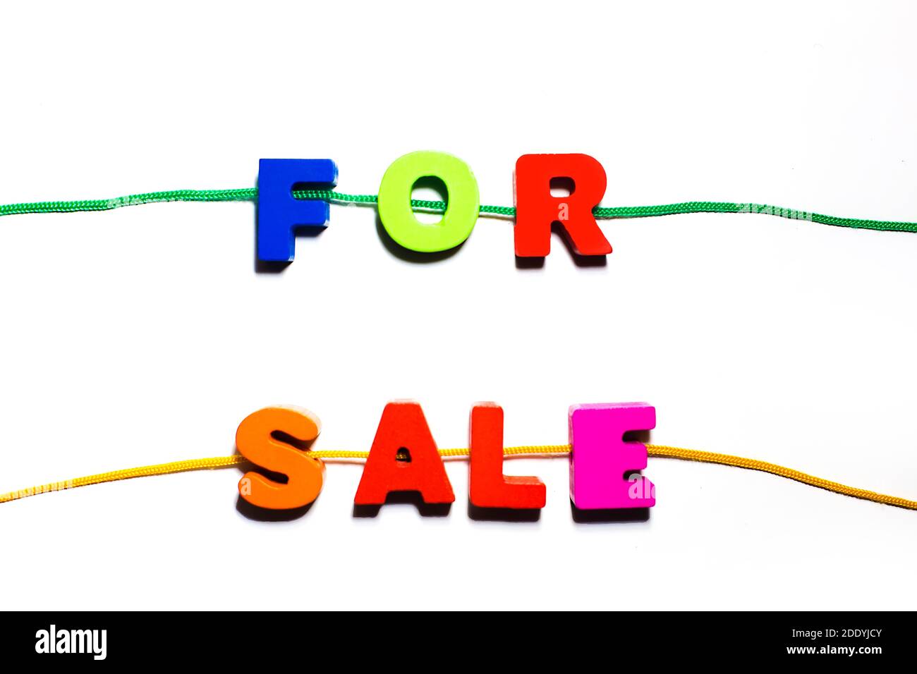 Zum Verkauf Wort Text aus Holz bunt bemalt abc Buchstaben mit Löchern geschrieben, aufgereiht auf einer Spitze, Einkaufen Kauf, Verkauf Konzept Stockfoto