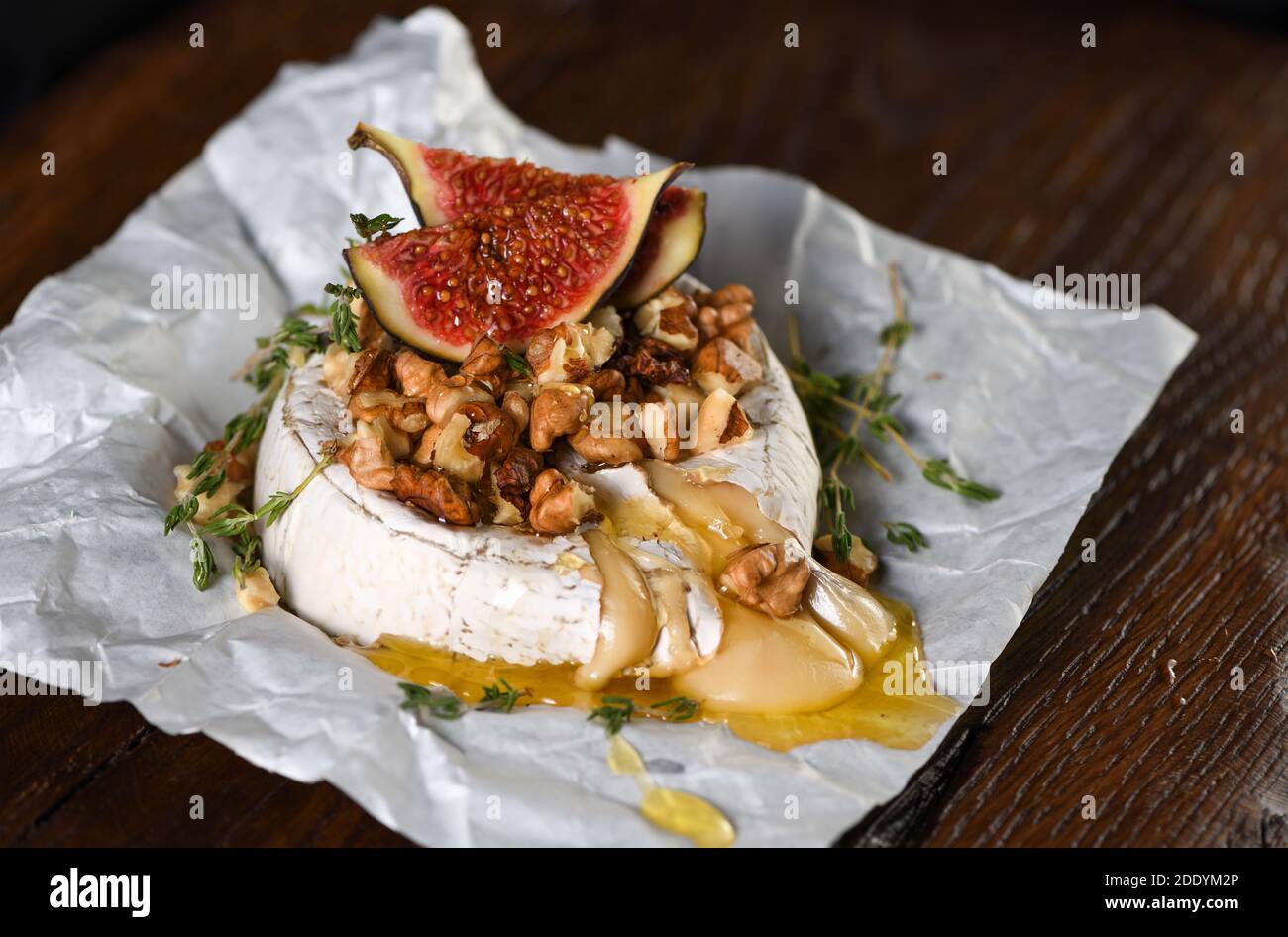 Gebackener Camembert mit Nüssen und Honig, Feigen- und Thymianscheiben. Stockfoto