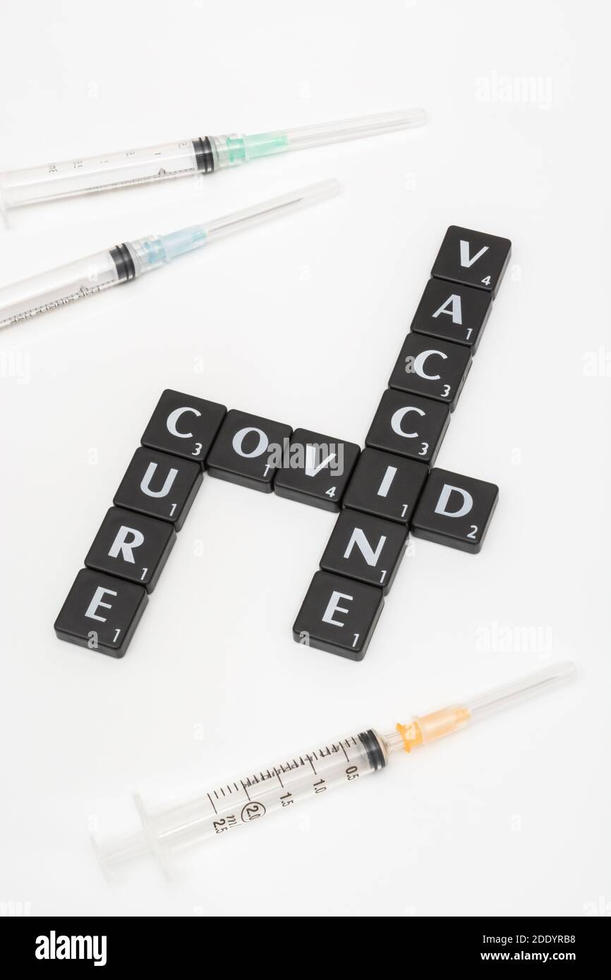 Buchstaben Kachel Matrix für Covid 19, UK Heilung covid, und Coronavirus / covid Impfstoff & Spritzen auf neutralem Hintergrund. Für den Kampf gegen den gefürchteten Covid 19 Stockfoto