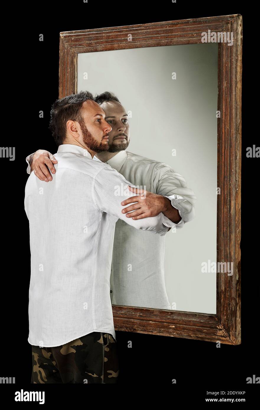 Der Mensch im Spiegel umarmt seine Reflexion. Stockfoto