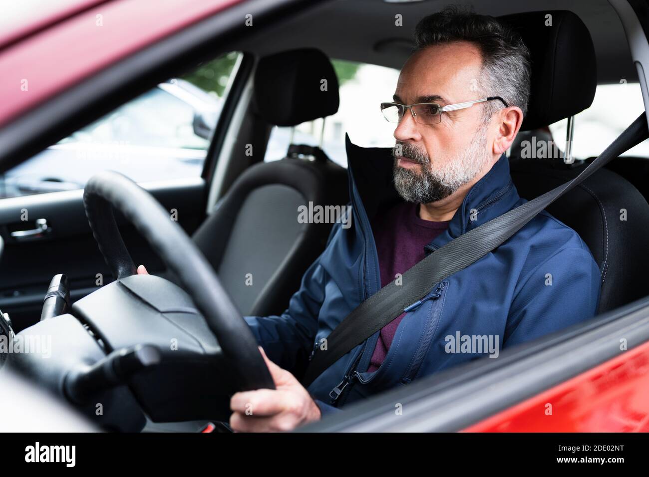 Senior Man Hält Das Lenkrad Während Der Fahrt Mit Dem Auto Stockfoto