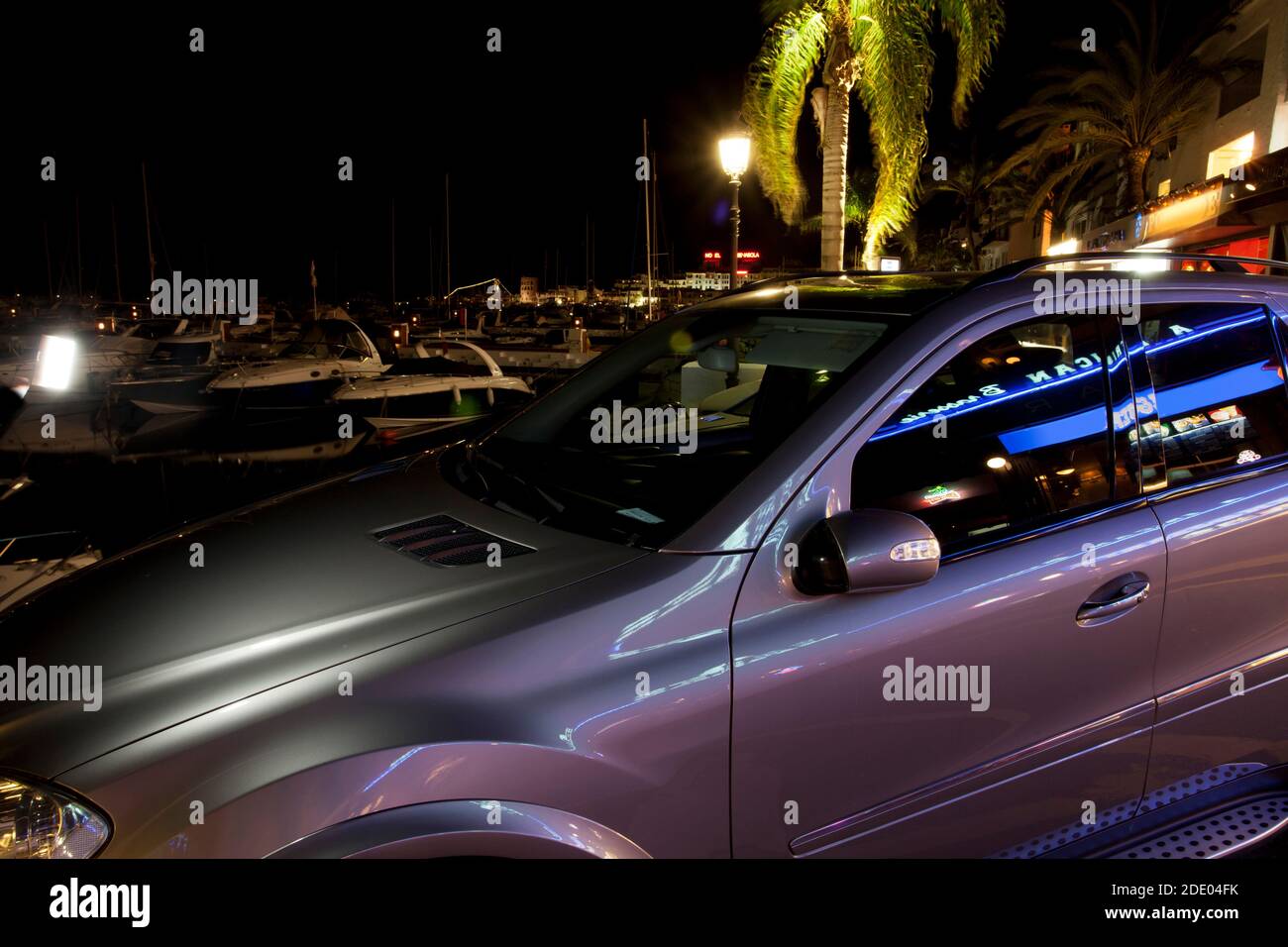 Der Hafen in Puerto bänd nachts, mit teuren Autos und Booten vor Anker Stockfoto