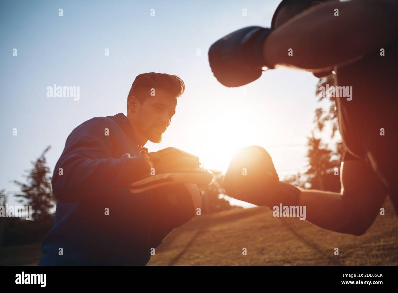 Sport Mann Boxer Training in Boxhandschuhen mit Personal Trainer Im Freien Stockfoto