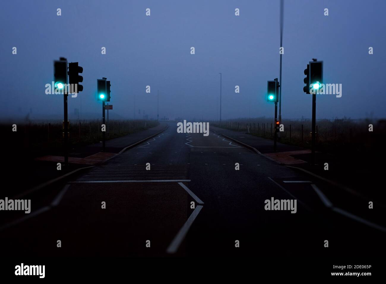 Grüne Ampel auf einer nebligen atmosphärischen Straße in Bingham, Nottinghamshire, England. Stockfoto