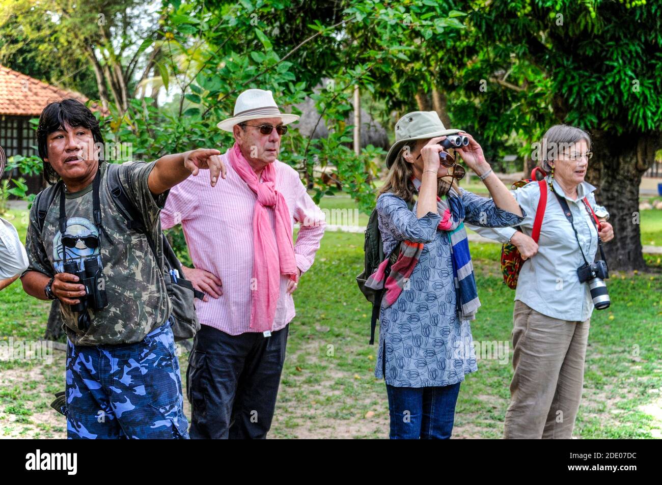 Ein Wildlife Guide, ein gebürtiger Pantanal Region, beobachtet durch sein Fernglas nach Zeichen der Wildtieraktivität, begleitet von seiner kleinen Gruppe von Stockfoto