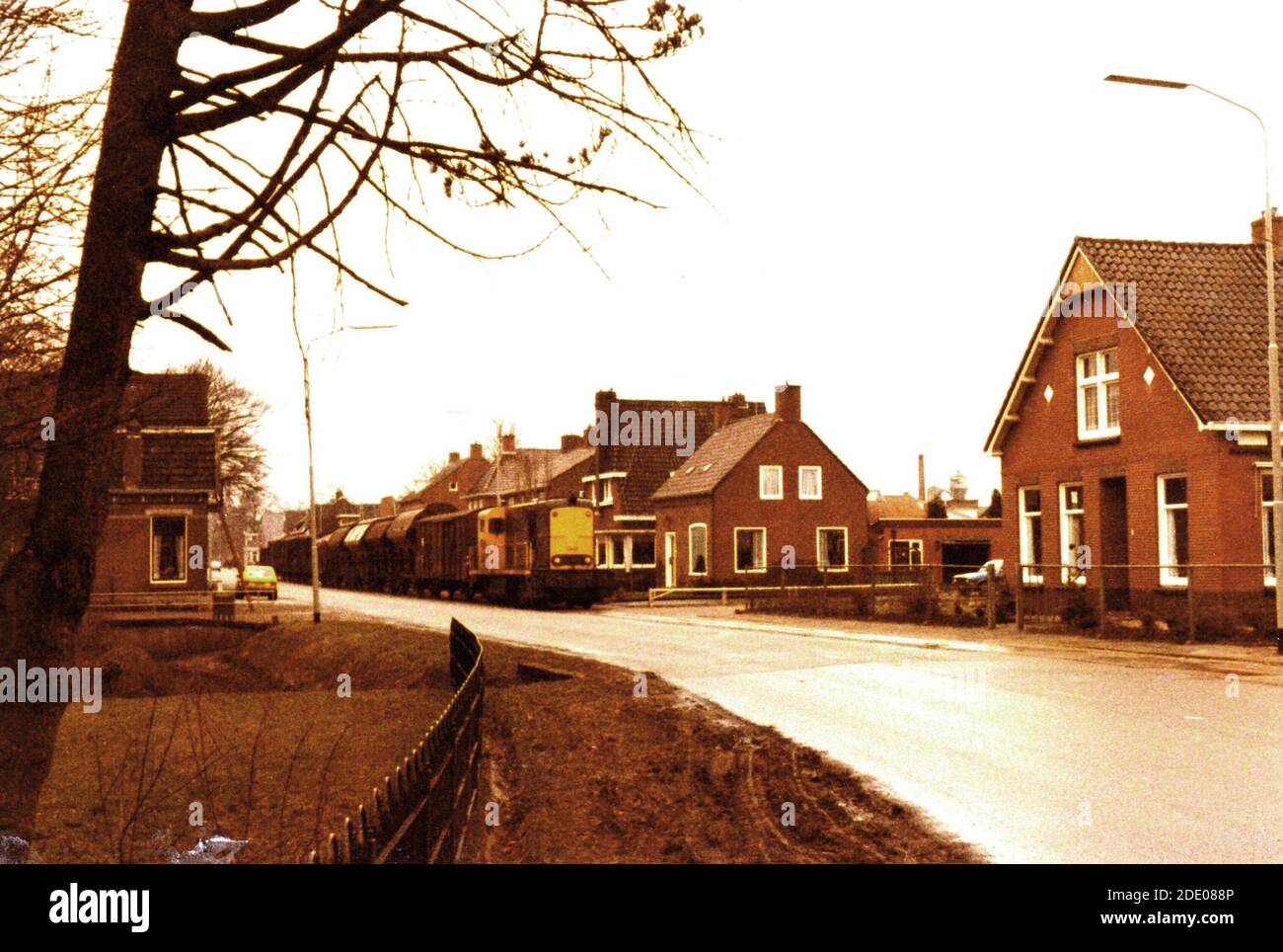 MARUM, Nederlands - Ostern 1979: Ein Güterzug kommt durch die Straße Kruisweg im Dorf Marum an der ehemaligen Tramlijn Groningen - Drachten auch genannt 'De Philipslijn'. Die Linie wurde 1985 geschlossen. Stockfoto