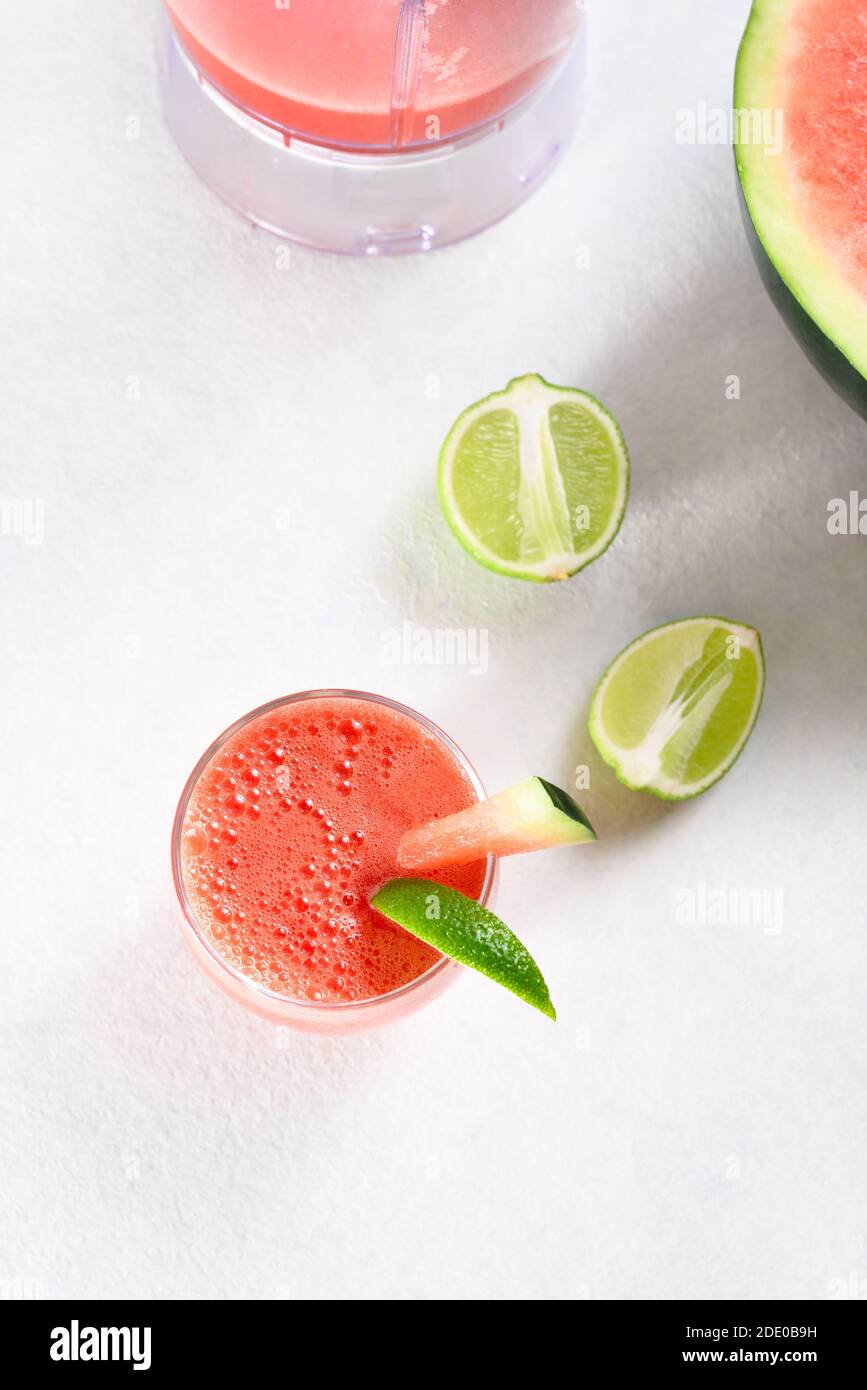 Wassermelone Saft in einem Glas auf weißem Stein Hintergrund. Gesundes Sommergetränk. Draufsicht, flach liegend Stockfoto