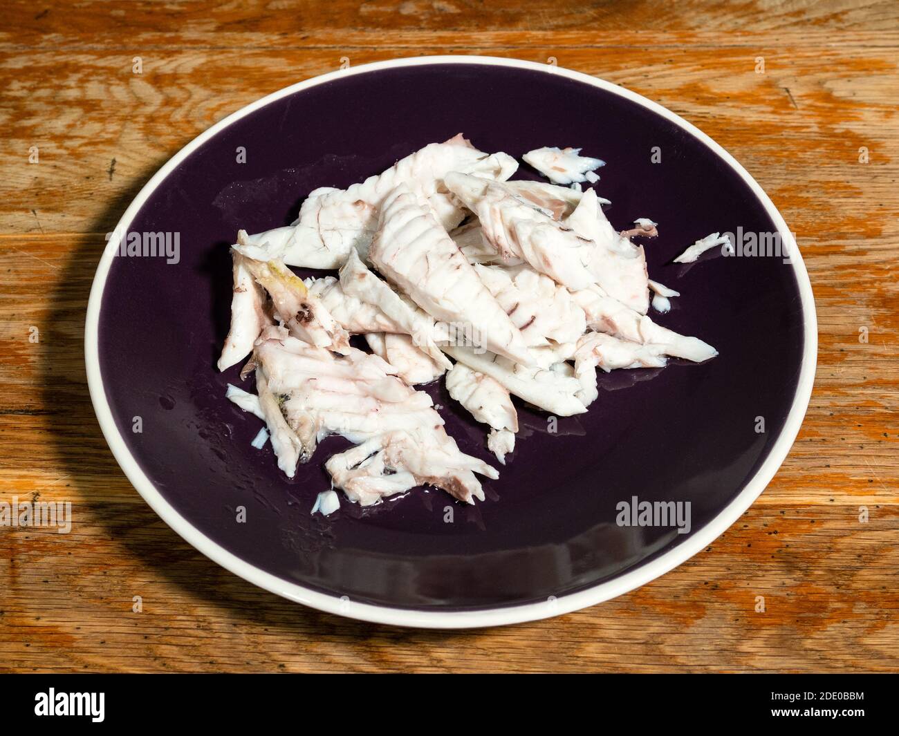 Entbeintes Filet von gebackenem Orata Fisch auf dunklem Teller Alte Holztisch in der heimischen Küche Stockfoto