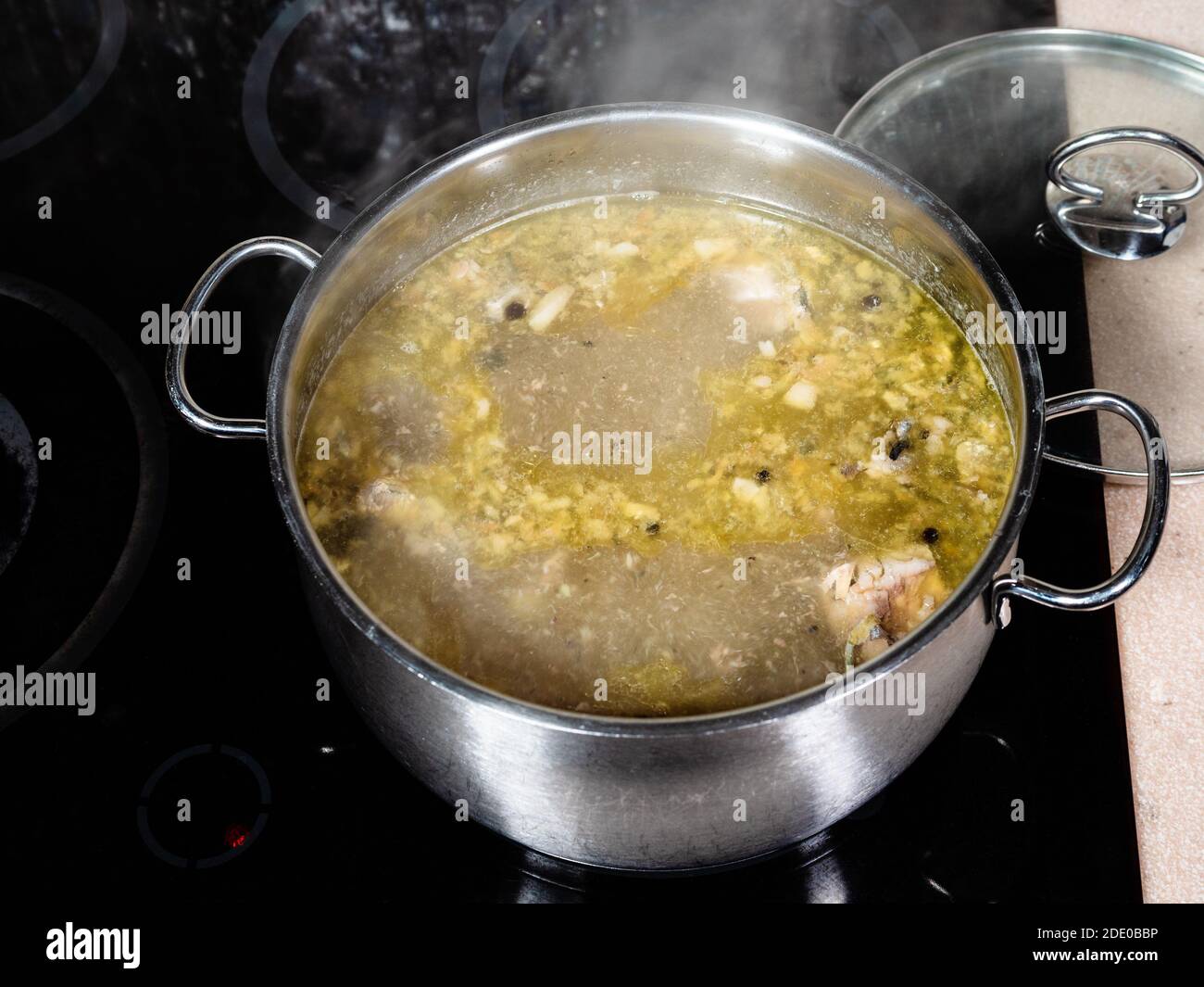 Oben Ansicht von Fischsuppe wird in Stockpot auf gekocht Keramikherd in der heimischen Küche Stockfoto