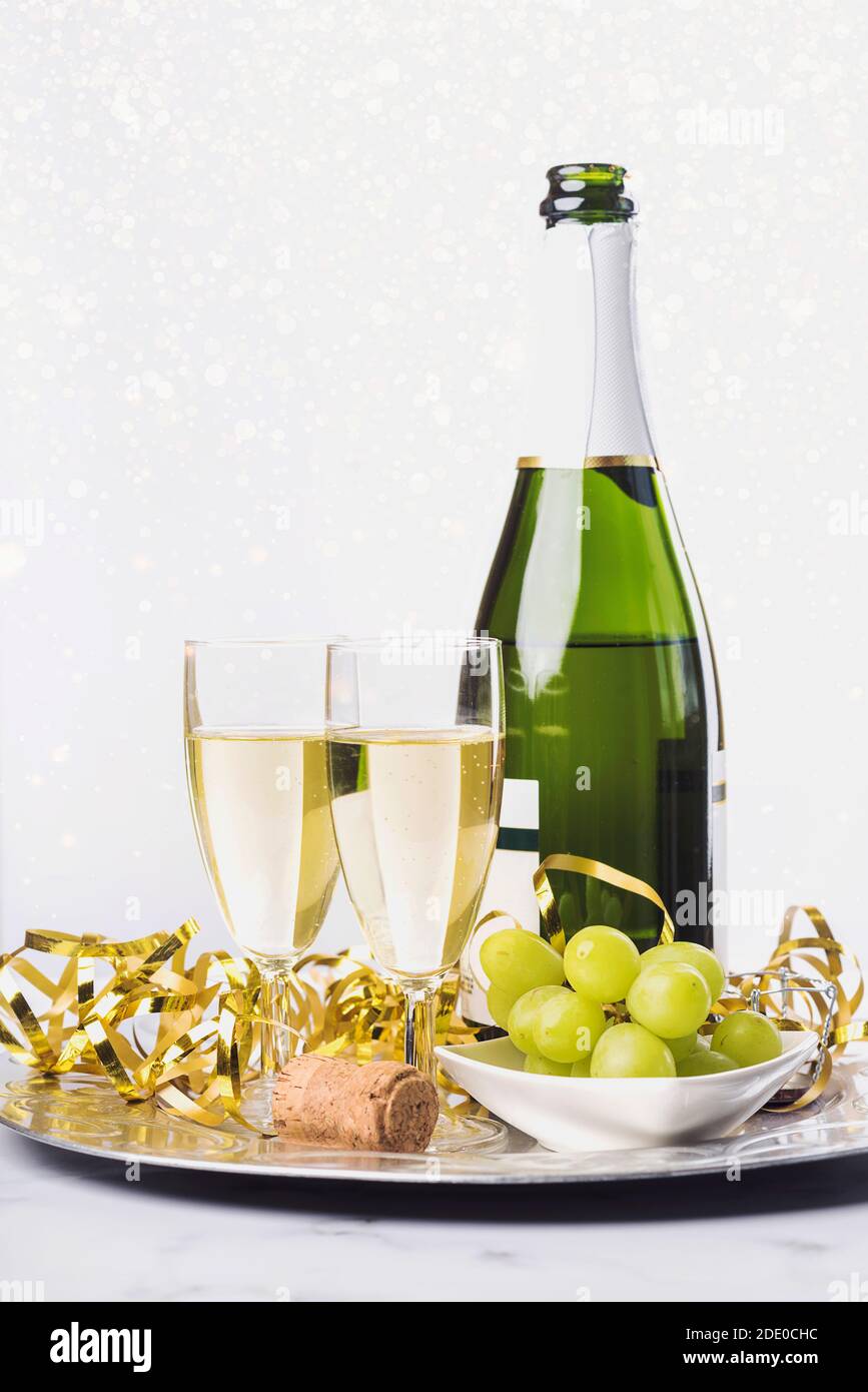 Silvester Feier Konzept Hintergrund. Champagner mit Glas und Trauben auf Marmortisch Stockfoto