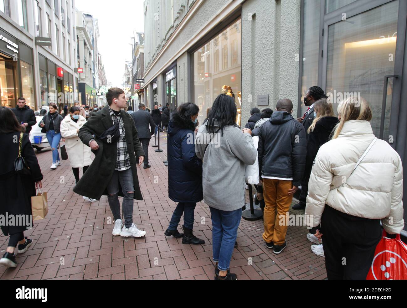 Verbraucher warten in der Schlange, um einen Laden während "Black Friday" in der Einkaufsstraße Kalverstraat inmitten der Coronavirus-Pandemie am 27. November 2020 i zu betreten Stockfoto