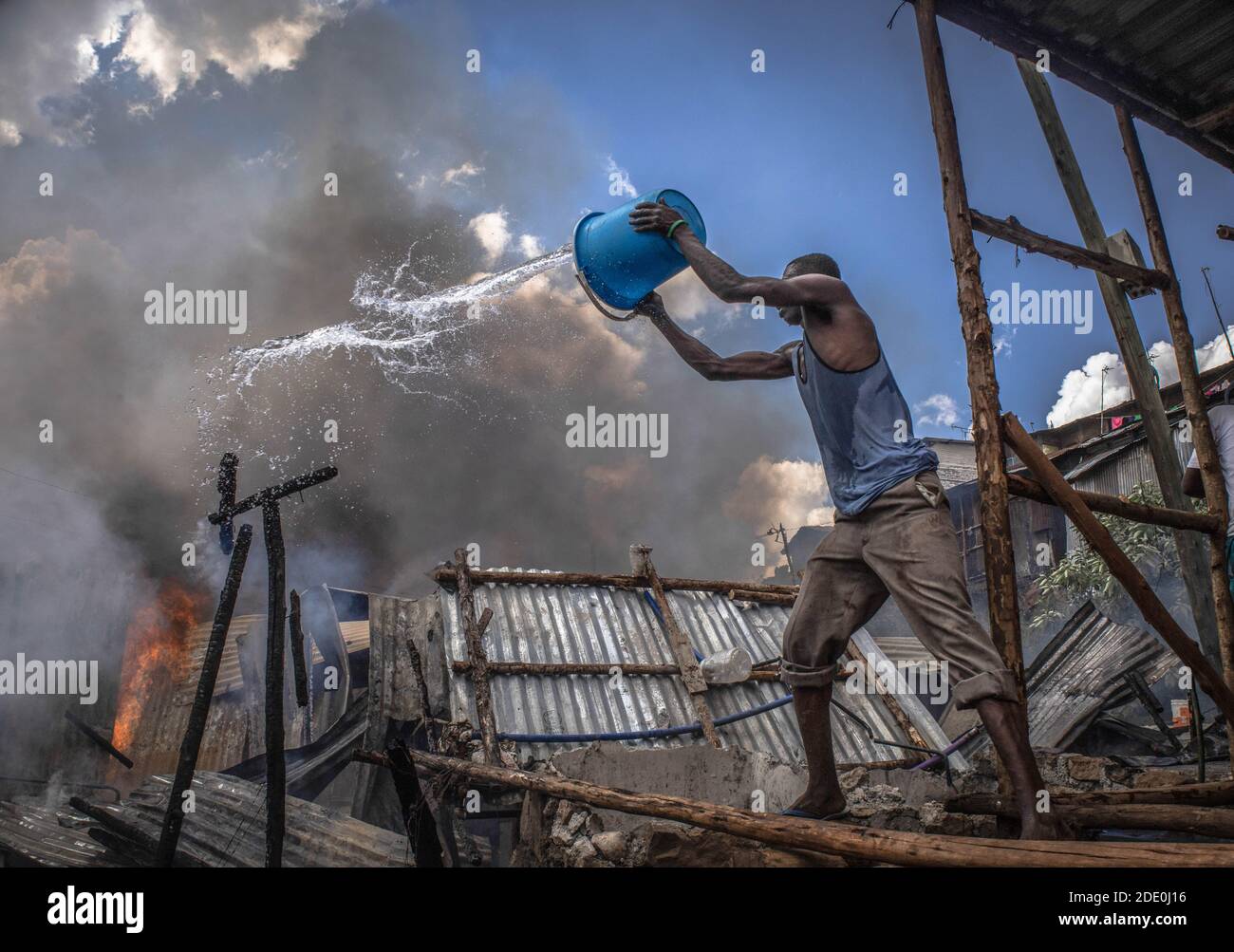 Bewohner aus dem Gebiet Kibera Soweto werden gesehen, wie sie mit ihren Wassereimern kämpfen, um das Feuer auszulöschen, das sich ausbreitet.tief im Nachbargebiet von Soweto in den Slums von Kibera, Die Bewohner erlebten einen harten verrückten Moment, nachdem eine Feuerbelagerung durch einen illegalen Stromanschluss dreißig Häuser niederschürte und die meisten Bewohner obdachlos wurden. Die meisten Einheimischen schlossen sich den Händen an, um das Feuer zu löschen, aber leider konnte nichts gerettet werden, aber es gab keine Menschenleben in der Situation. Stockfoto