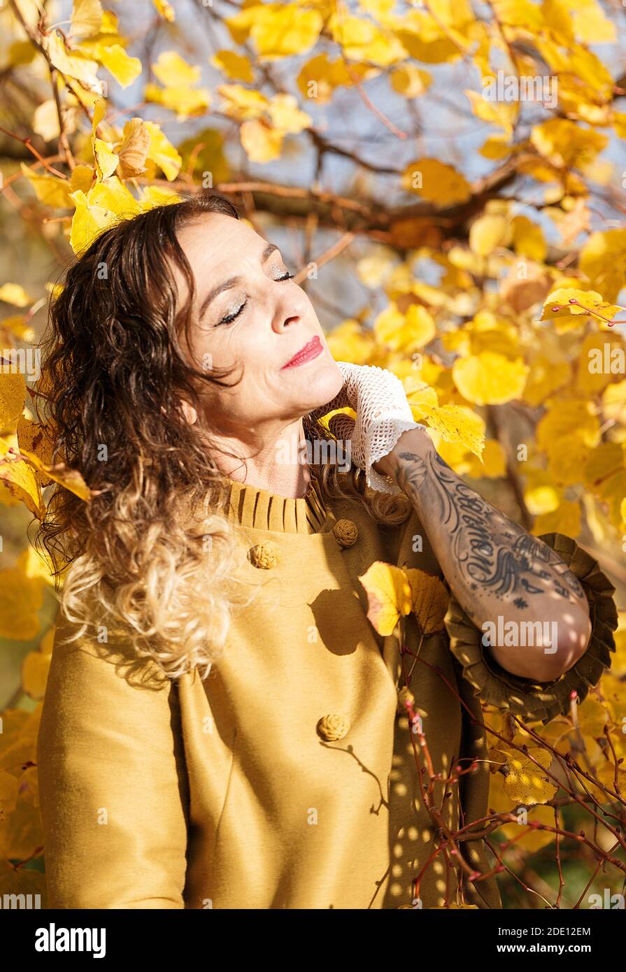 Frau zwischen gelben Herbstblättern II Stockfoto