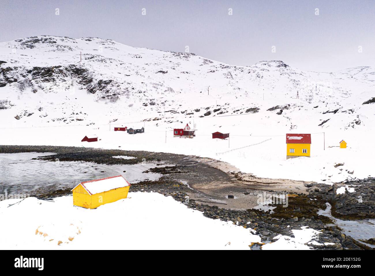 Bunte Holzhäuser im schneebedeckten Fischerdorf Breivikbotn, Soroya Island, Hasvik, Troms Og Finnmark, Arktis, Norwegen Stockfoto