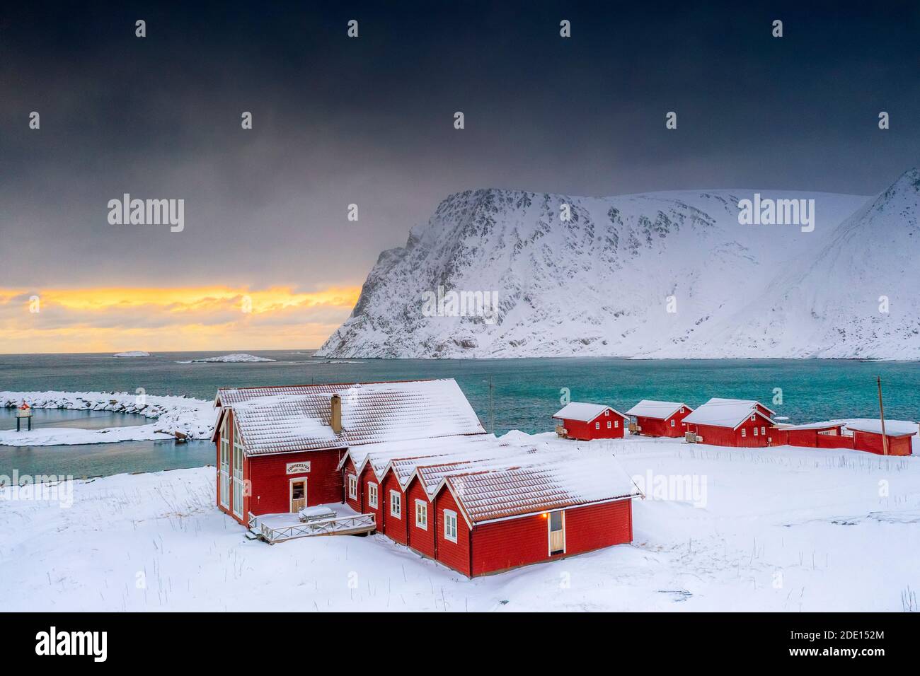 Winter Sonnenuntergang über dem arktischen Meer und Fischerhütten im Schnee, Sorvaer, Soroya Island, Hasvik, Troms Og Finnmark, Norwegen, Skandinavien, Europa Stockfoto