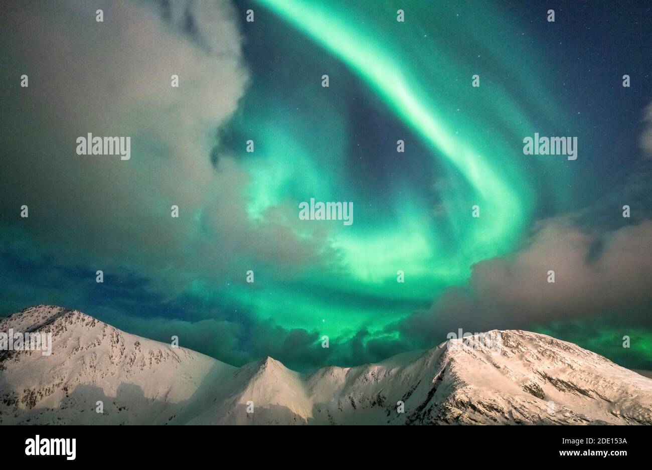 Nordlichter (Aurora Borealis) über schneebedeckten Berggipfeln, Sorvaer, Soroya Island, Hasvik, Troms Og Finnmark, Norwegen Stockfoto