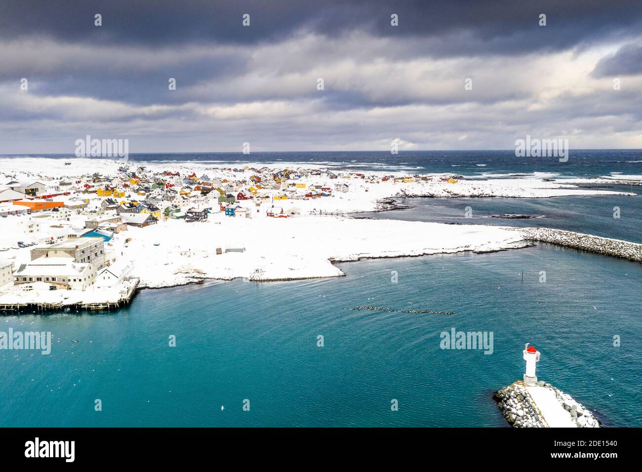 Sturmwolken über Leuchtturm und Berlevag Dorf mit Schnee bedeckt, Barentssee, Varanger Halbinsel, Troms Og Finnmark, Norwegen, Skandinavien, Europa Stockfoto