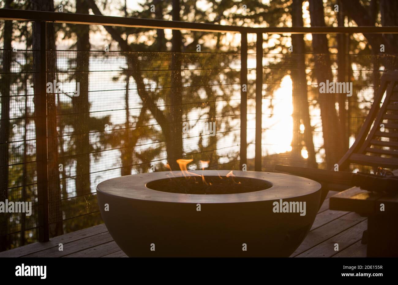 Gasfeuerstelle auf einer Terrasse mit Blick auf das Meer Sichtbare Flammen bei Sonnenuntergang Stockfoto