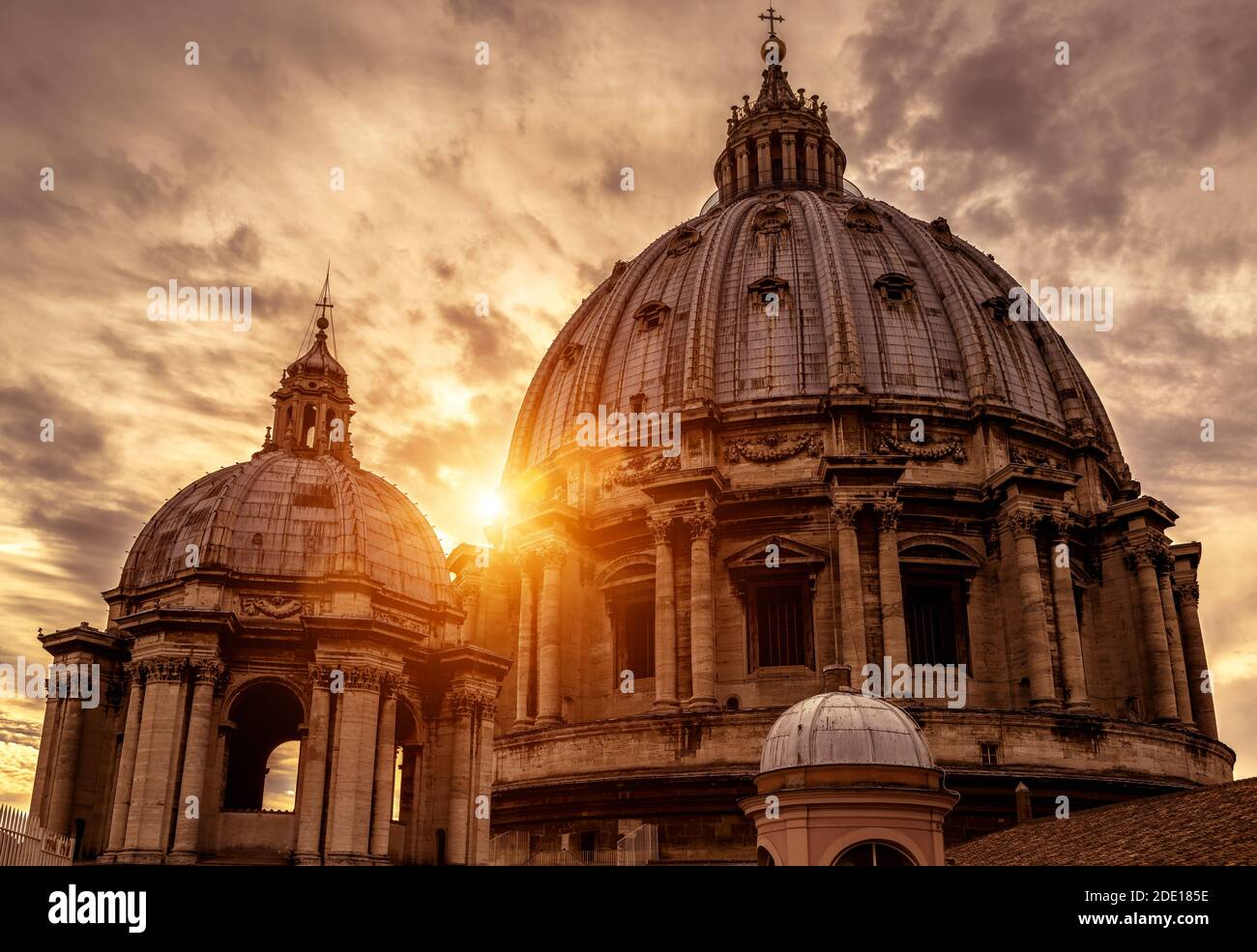 Petersdom (San Pietro) bei Sonnenuntergang in Vatikanstadt, Rom, Italien. Der große Petersdom ist ein berühmtes Wahrzeichen Roms. Sonniger Blick auf Baroq Stockfoto