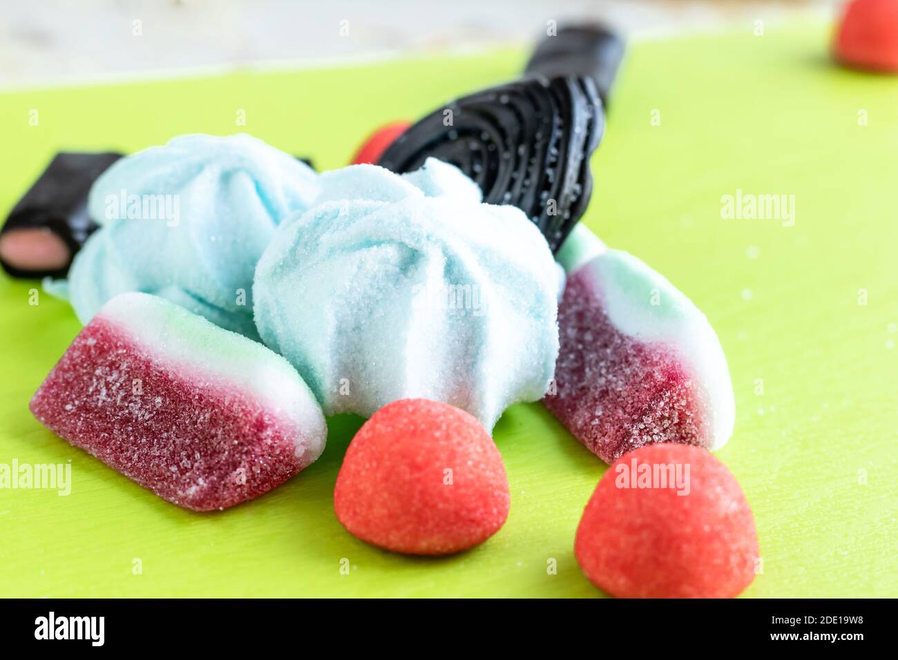 Bunte italienische Süßigkeiten für Party: Schwarze Süßholz Süßigkeiten verstreut chaotisch auf einem grünen Hintergrund weichen Fokus Foto. Stockfoto