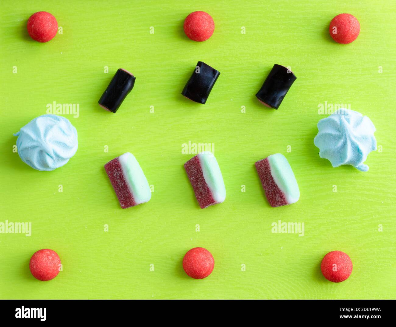 Süßes Muster-Flachlappen für Süßwarenladen, bunte italienische Süßigkeiten: Marmelade, Marshmallow und Lakritz auf grünem Hintergrund. Stockfoto