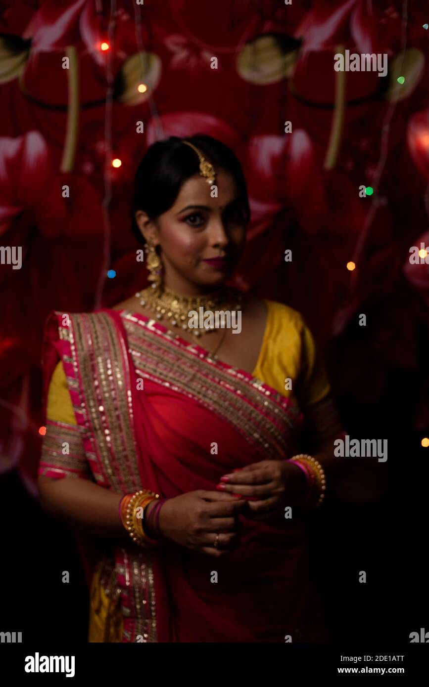 Porträt einer jungen und schönen indischen Bengali Frau in indischen traditionellen Kleid vor bunten Bokeh Lichter. Indischer Lebensstil und Diwali Stockfoto