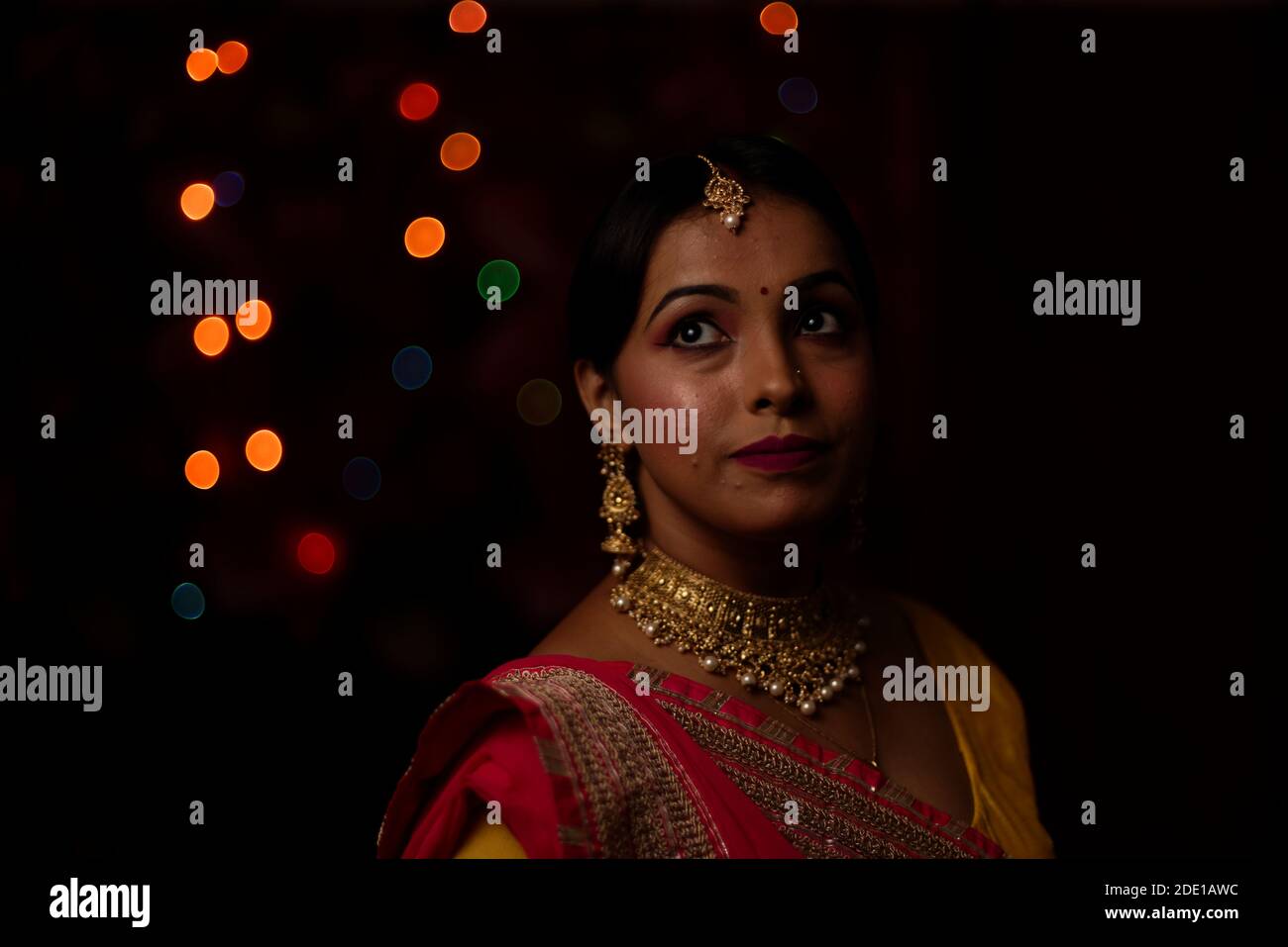 Porträt einer jungen und schönen indischen Bengali Frau in indischen traditionellen Kleid vor bunten Bokeh Lichter. Indischer Lebensstil und Diwali Stockfoto