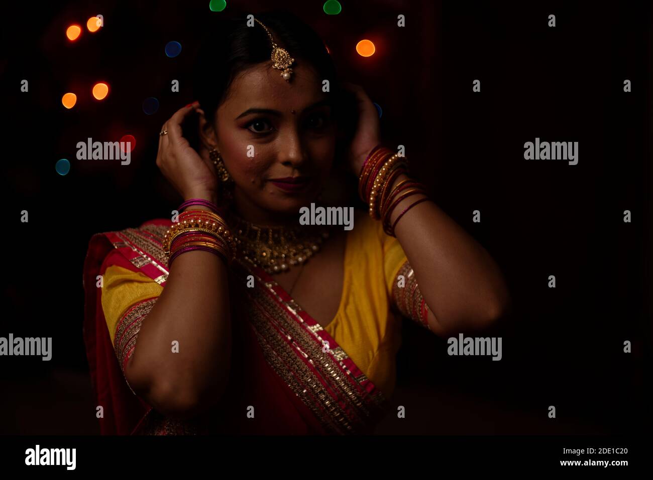 Eine junge und schöne indische Bengalin feiert Diwali in indischen traditionellen Kleid vor bunten Bokeh Lichter. Indischer Lebensstil Stockfoto