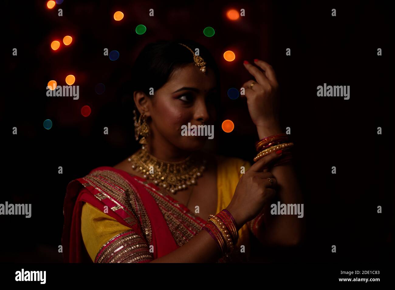 Eine junge und schöne indische Bengalin feiert Diwali in indischen traditionellen Kleid vor bunten Bokeh Lichter. Indischer Lebensstil Stockfoto