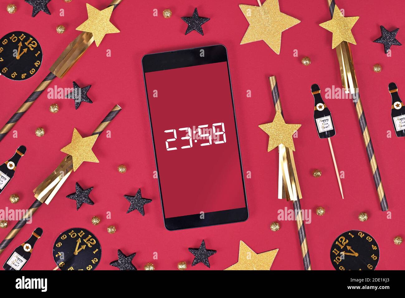 Silvester Festkonzept mit Smartphone mit Timer Countdown bis Mitternacht zwischen Party-Elemente wie Papier Trinkhalme und Papierchampaign bot Stockfoto
