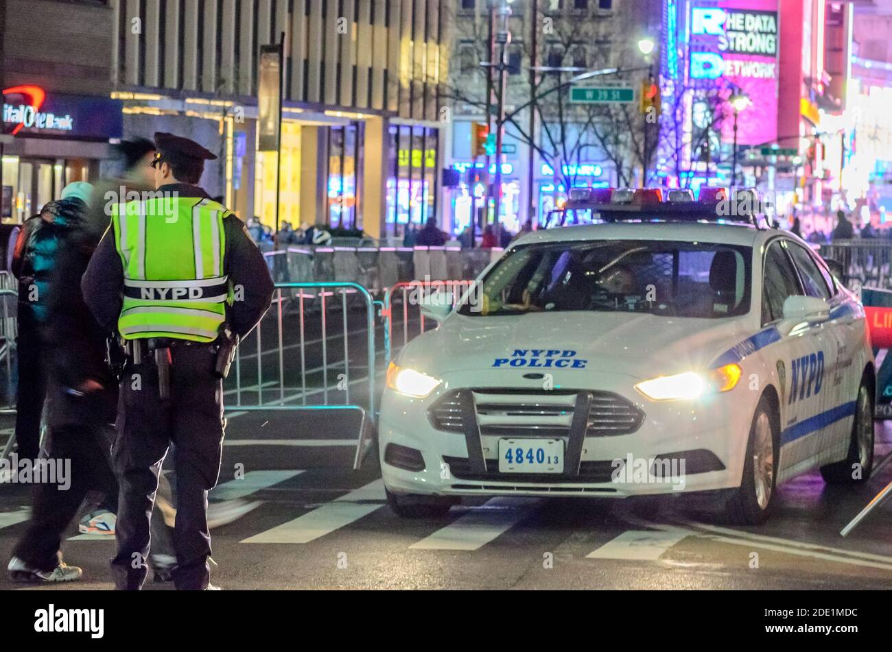 Silvesterfeier im Times Square Manhattan. Die Polizei von New York hat den Massen den Weg versperrt. Offizier patrouelt die Straße. Stockfoto