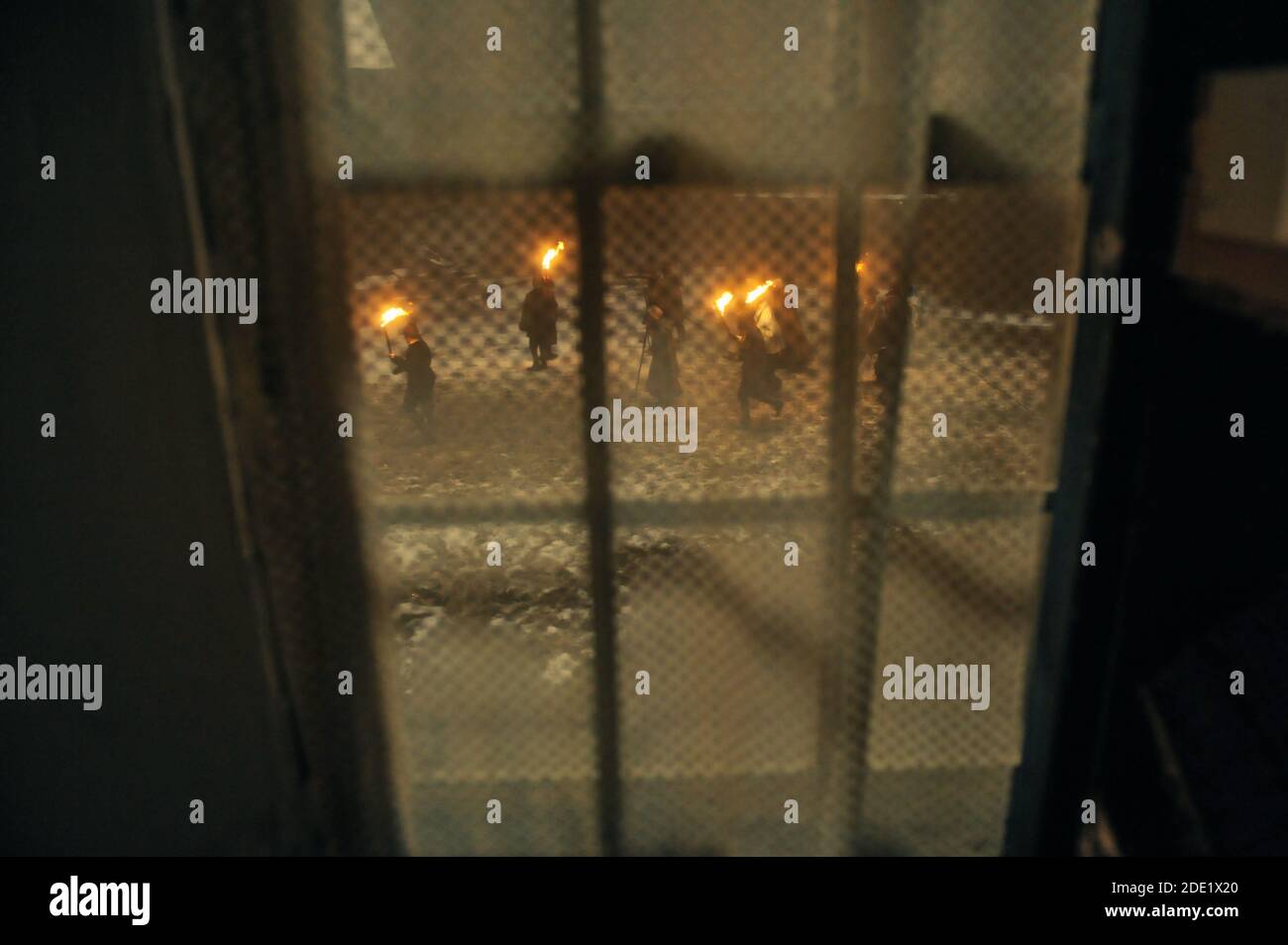 People with torches run outside a medieval house during a winter night - witch hunt concept. Stockfoto