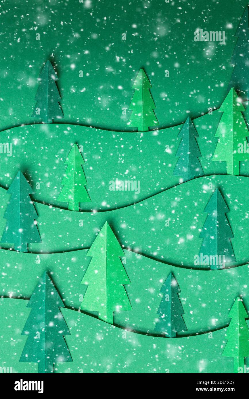 3D Pop out Weihnachtsbäume Papier Kunstwerk im grünen Hintergrund mit Schneeflocken. Weihnachtsbaum Papier schneiden Design-Karte. Draufsicht. Flach liegend Stockfoto