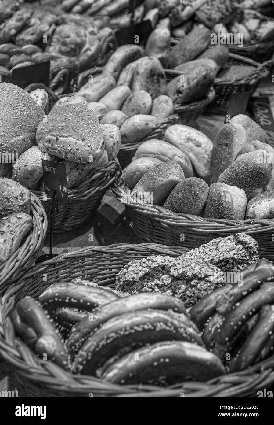 Schwarz-Weiß-Bild von einer Auswahl von Broten und Brezeln in Körben zum Verkauf in einer Bäckerei Stockfoto