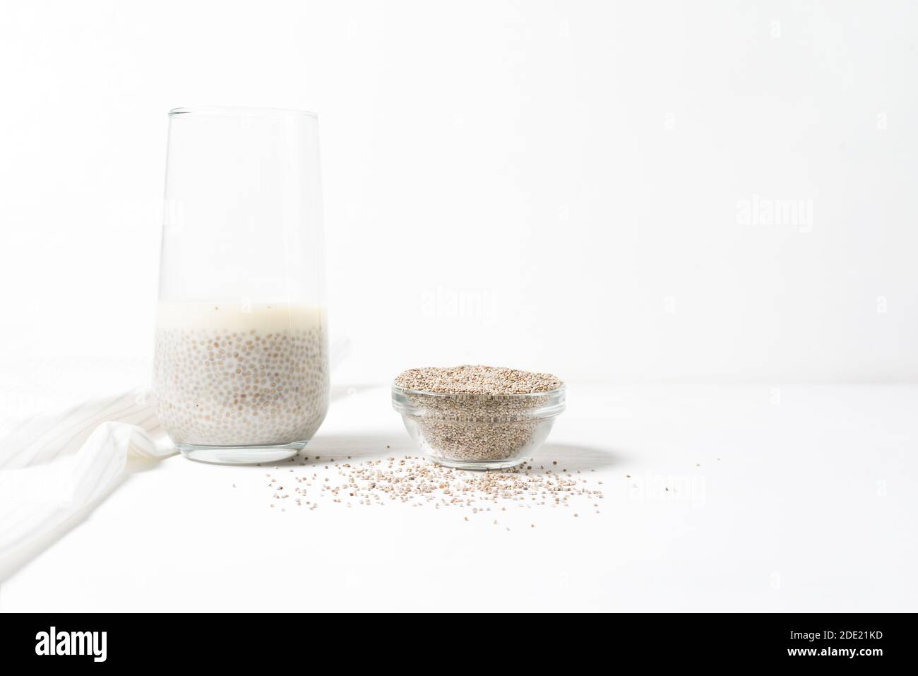 Eingetaucht in ein Glas weißer Chia-Samen auf hellem Hintergrund, trocken Chia in einer Glasplatte, vegetarische gesunde Lebensmittel mit Omega und Vitaminen. Superfood fo Stockfoto