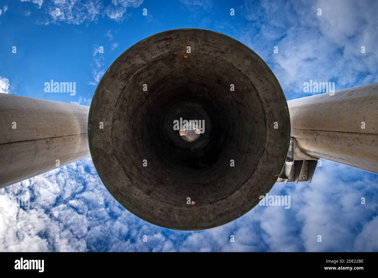 Große Glocke (Glocke des Friedens) mit Klapper auf blauem Himmel mit Wolken, niedrige Winkel Ansicht. Denkmal des Ersten Weltkriegs in Rovereto, Trentino, Italien, EU. Stockfoto