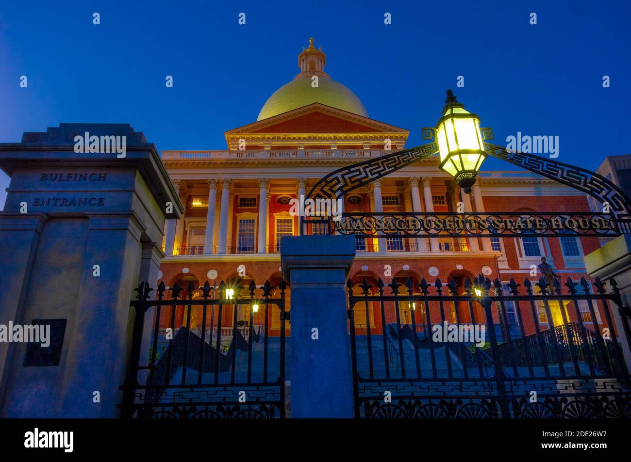 Boston, MA --Aug 26, 2018; niedriger Winkel Ansicht des vorderen Eingangstors zum Massachusetts Statehouse beleuchtet in der Dämmerung Stockfoto