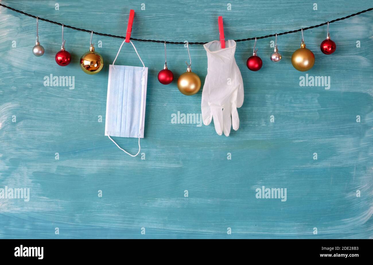 weihnachten in Zeiten der Corona Virus Lockdown, weihnachtskugeln, OP-Handschuhe, Gesichtsmaske, Symbol Bild, freie Kopie Raum Stockfoto