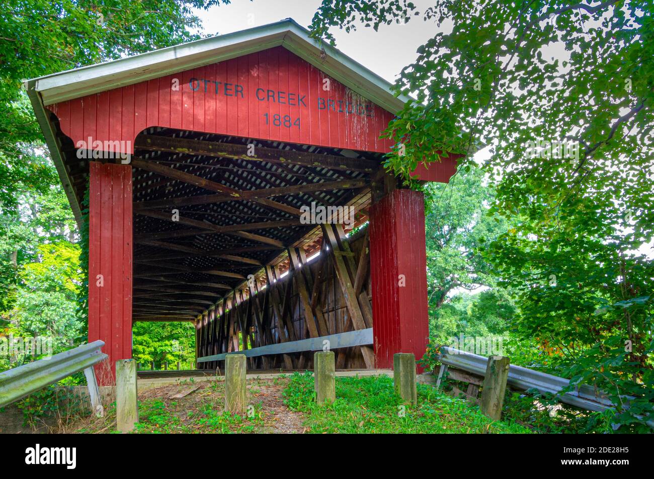 Ripley County, IN--Aug 18, 2018; Eingang zu roten hölzernen bedeckten Otter Creek Brücke im ländlichen Indiana umgeben von Bäumen im Sommer Stockfoto