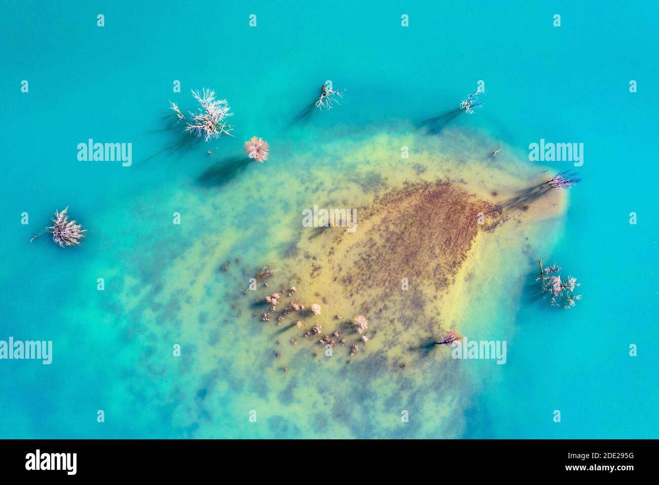 Top down Luftaufnahme des eisblauen Wassers und Ufer des Sotonera Stausees mit spanischen Pyrenäen im Hintergrund bei Huesca, Spanien Stockfoto