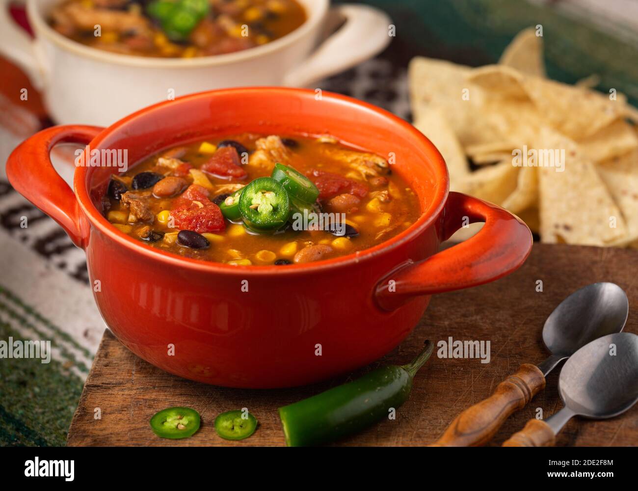 Leckere Schüssel mit würziger Chicken Taco Suppe in einer Orange Schüssel mit Tortilla Chips Stockfoto