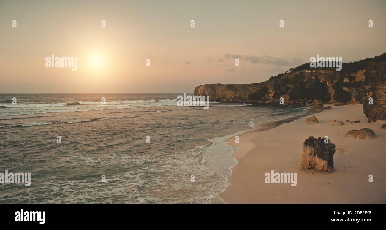 Sandstrand mit Klippenufer der Meeresbucht Luftaufnahme. Sonnenaufgang über der Uferpromenade des Meeresgolfs. Niemand Sommersonne steigt Seenlandschaft mit sandiger Küste und Steinen. Filmisches Sonnenlicht weich bei Drohnenaufnahme Stockfoto