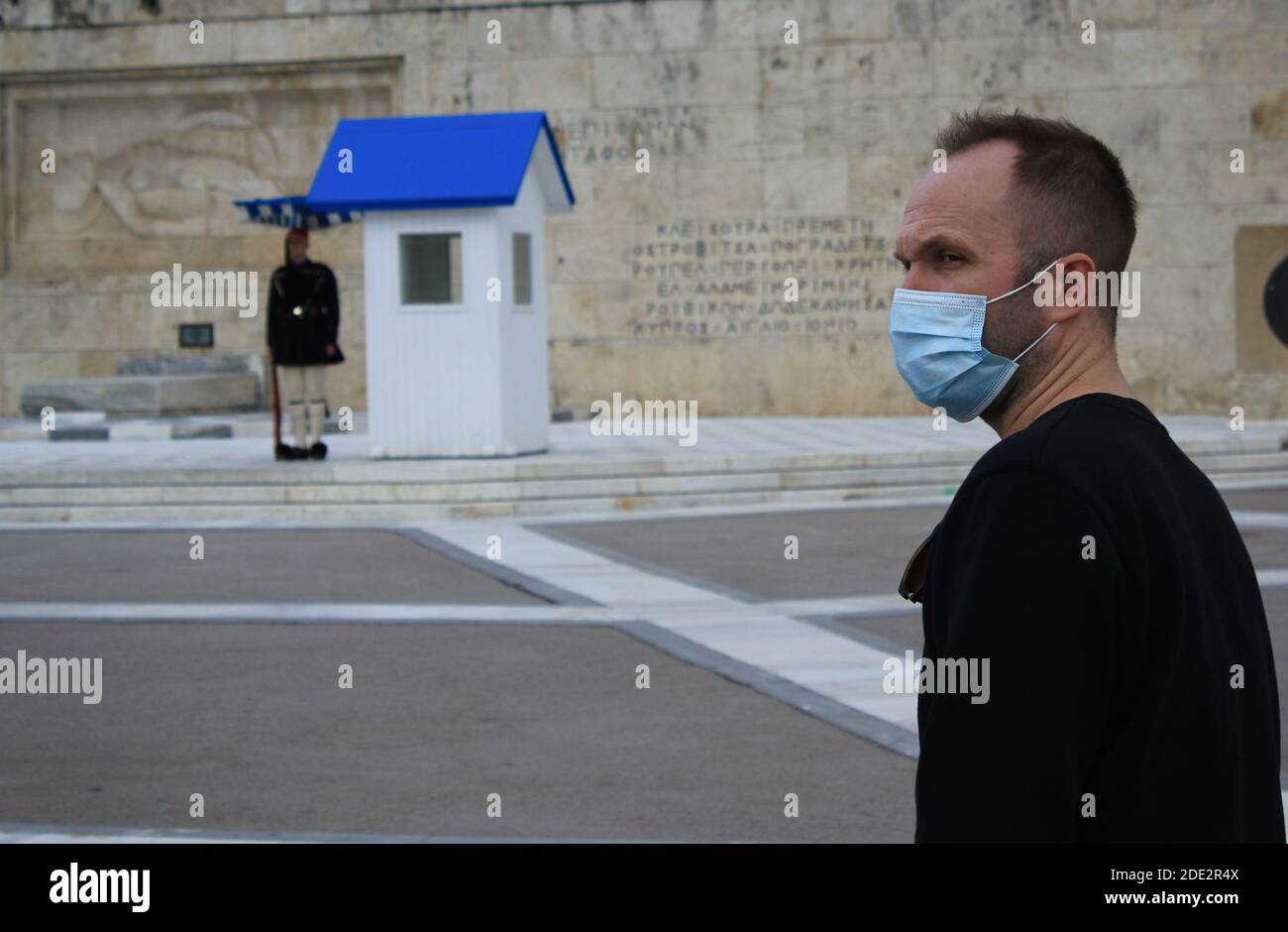 Mann mit Maske steht vor dem Grab des unbekannten Soldaten im griechischen Parlament in Athen, Griechenland, 6. November 2020. Stockfoto